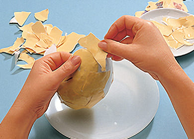 Klä sedan två ägghalvor av styrolit eller kartong med de omönstrade pappersbitarna